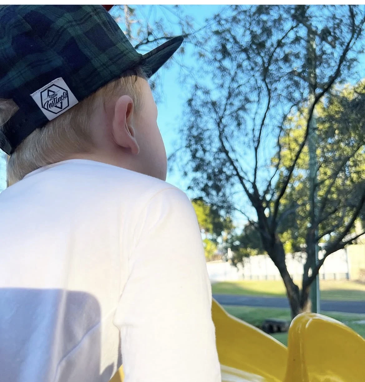 Child wearing a Little Instincts hat outdoors